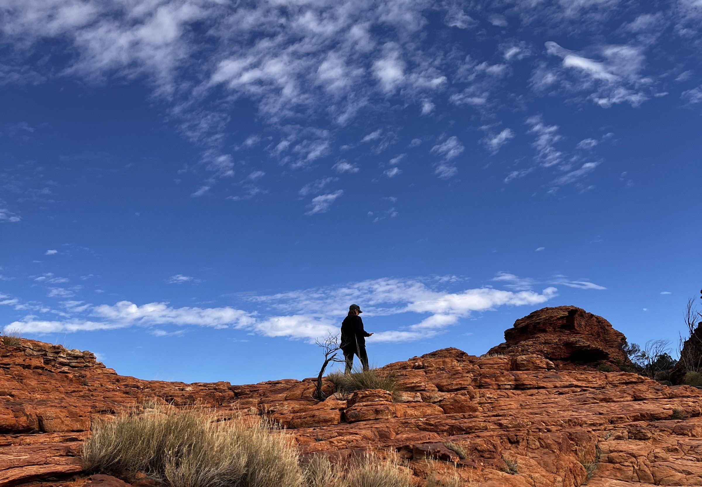 A lone figure on a ridge against a wide sky